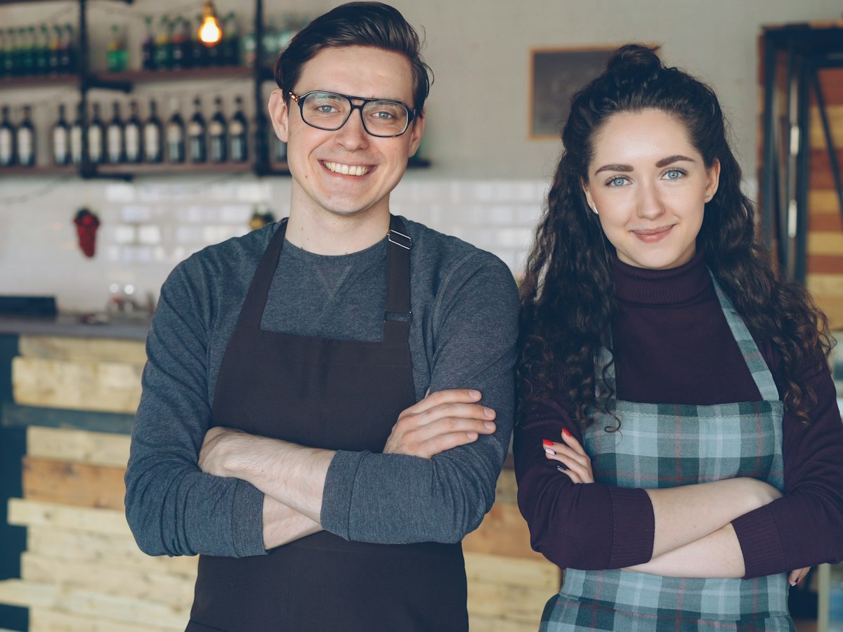 Two café owners standing proudly in their shop